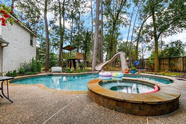 view of pool featuring an in ground hot tub and a water slide