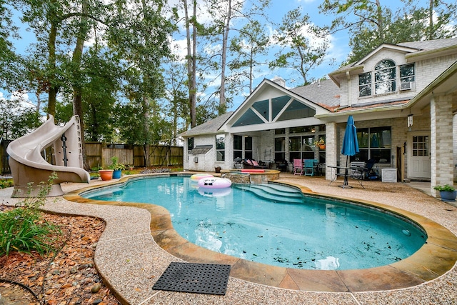 view of pool featuring an in ground hot tub, a patio area, and a water slide