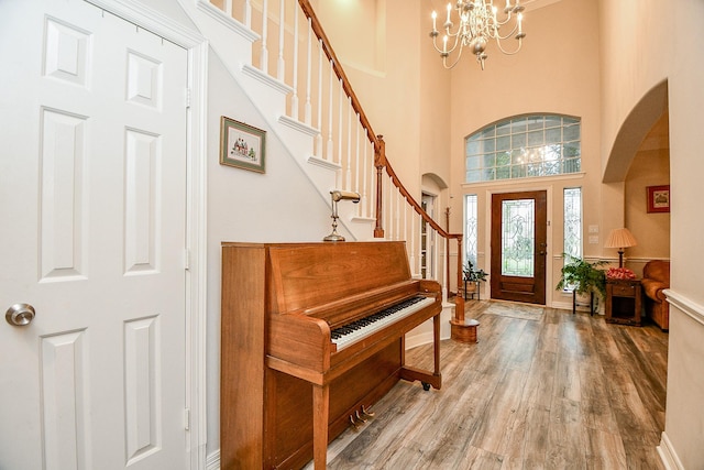 entryway with a chandelier, a high ceiling, and wood-type flooring