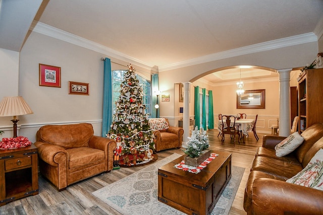 living room featuring hardwood / wood-style flooring, ornate columns, and ornamental molding