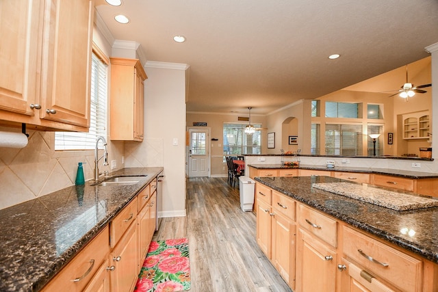 kitchen featuring decorative light fixtures, crown molding, sink, and a wealth of natural light