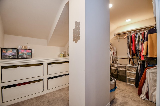 spacious closet with light colored carpet and lofted ceiling