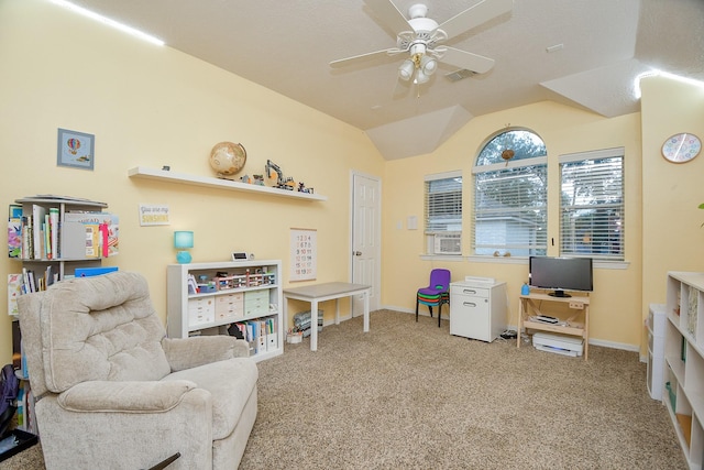 living area with ceiling fan, carpet floors, and vaulted ceiling