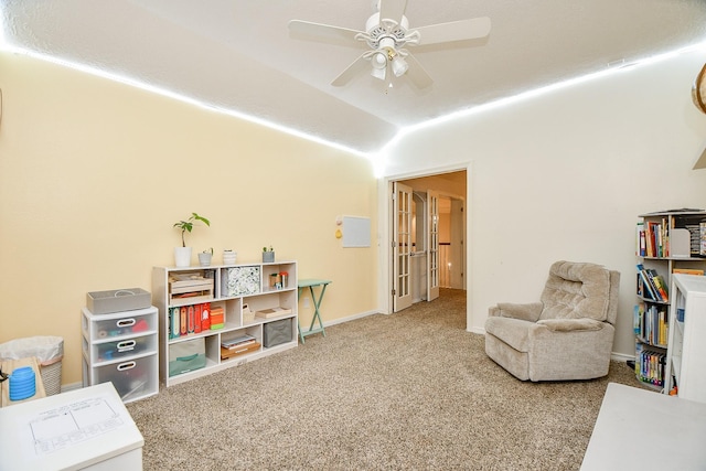 living area with carpet floors, ceiling fan, and lofted ceiling