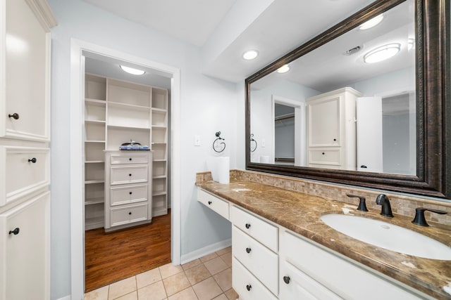 bathroom featuring tile patterned floors, vanity, and backsplash