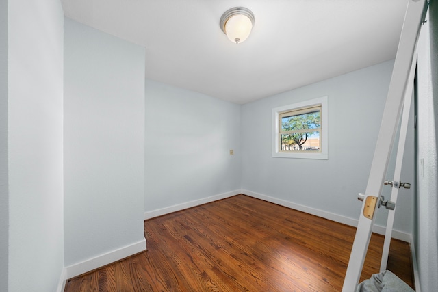 unfurnished room with dark hardwood / wood-style flooring