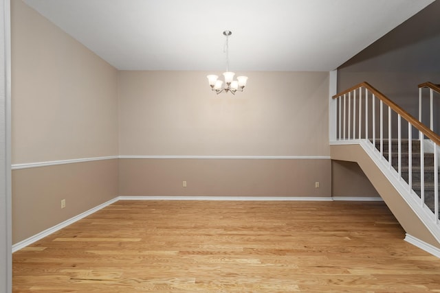 unfurnished room featuring light hardwood / wood-style floors and a chandelier