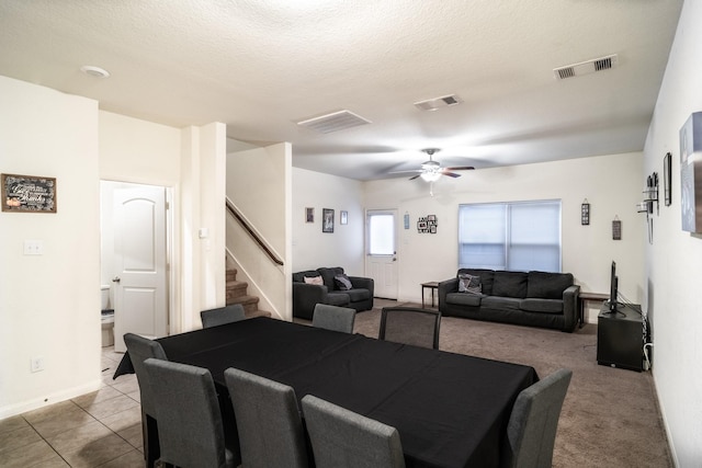 tiled dining area featuring a textured ceiling and ceiling fan