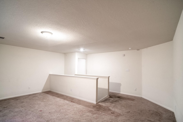 empty room featuring carpet and a textured ceiling