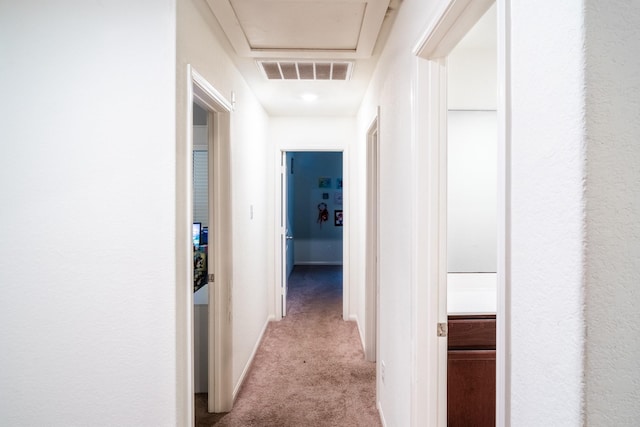 corridor featuring light colored carpet