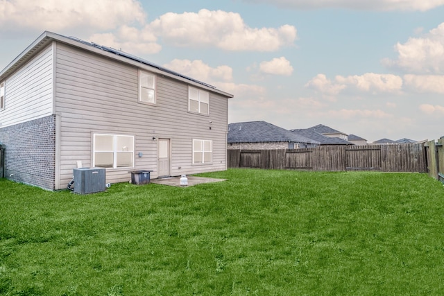 rear view of property featuring central AC, a yard, and a patio