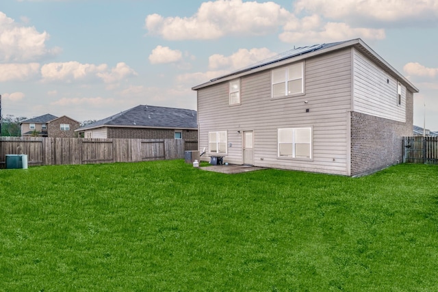 rear view of house featuring a lawn, a patio area, and central AC unit