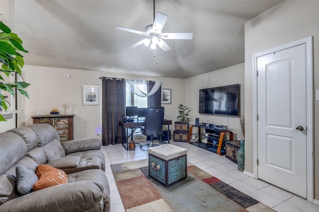 living room featuring ceiling fan, light tile patterned floors, and a textured ceiling