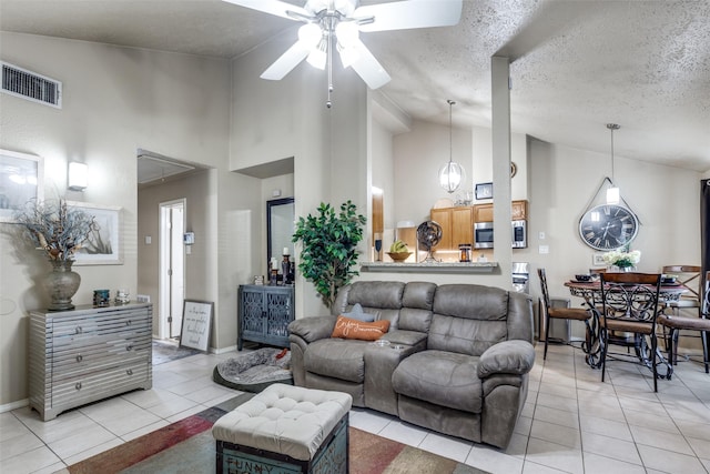 tiled living room with a textured ceiling, high vaulted ceiling, and ceiling fan