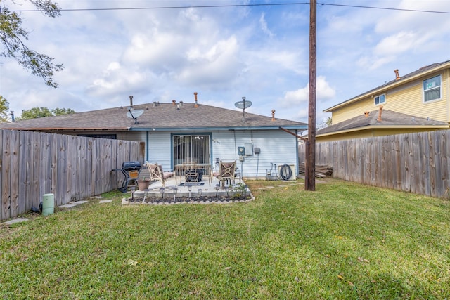 rear view of house with a lawn and a patio