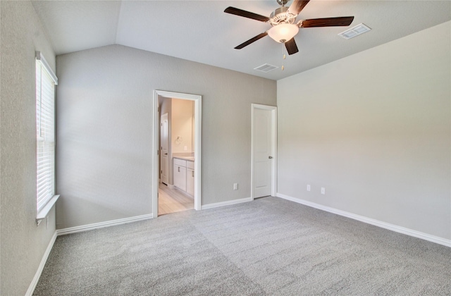 carpeted spare room with ceiling fan, a wealth of natural light, and vaulted ceiling