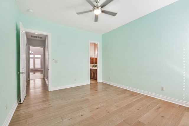 empty room with ceiling fan and light hardwood / wood-style flooring