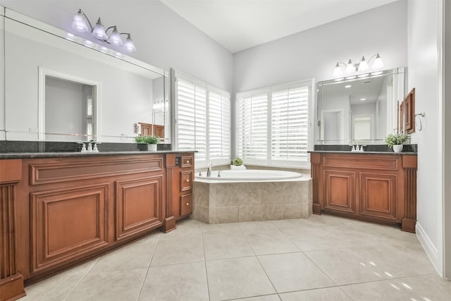 bathroom featuring vanity, a relaxing tiled tub, and tile patterned floors