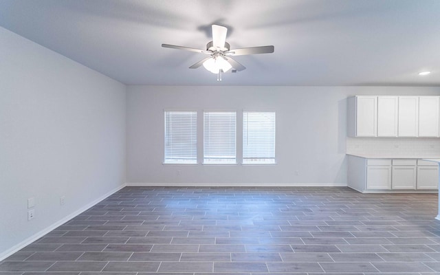 empty room with ceiling fan and dark hardwood / wood-style flooring