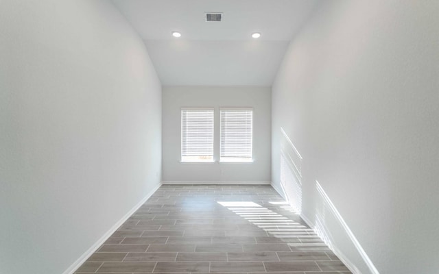 empty room featuring hardwood / wood-style flooring and lofted ceiling