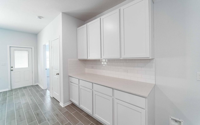 interior space featuring white cabinets, decorative backsplash, and dark hardwood / wood-style flooring