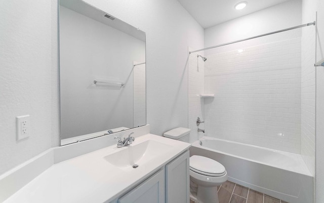 full bathroom with vanity, hardwood / wood-style flooring, toilet, and tiled shower / bath