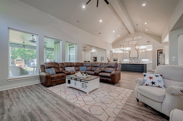 living room featuring ceiling fan, light hardwood / wood-style floors, beam ceiling, and high vaulted ceiling