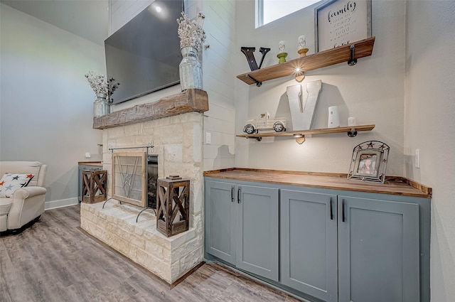 interior space featuring gray cabinets, light hardwood / wood-style floors, a high ceiling, and wood counters