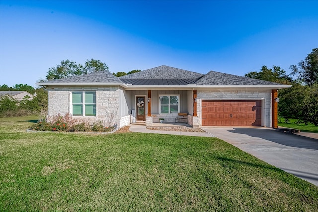 view of front of property with a front yard, a garage, and covered porch