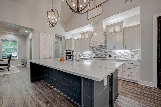 kitchen with white cabinetry, high vaulted ceiling, premium range hood, pendant lighting, and a spacious island