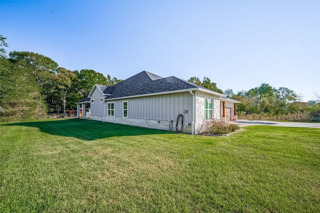 view of side of home with a yard