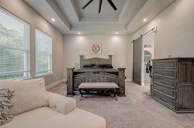 carpeted bedroom featuring a raised ceiling, a barn door, and ceiling fan