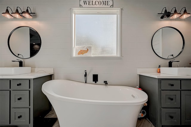 bathroom featuring a washtub and vanity