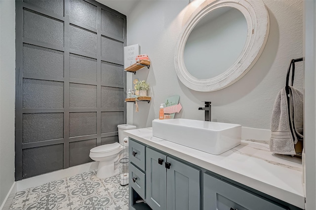 bathroom with tile patterned flooring, vanity, and toilet