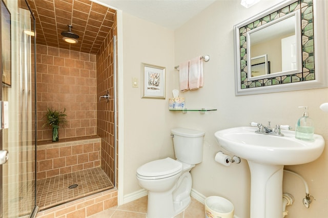 bathroom featuring tile patterned floors, sink, toilet, and walk in shower