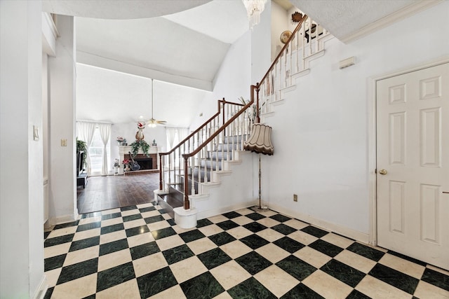 entrance foyer with ceiling fan, wood-type flooring, and high vaulted ceiling