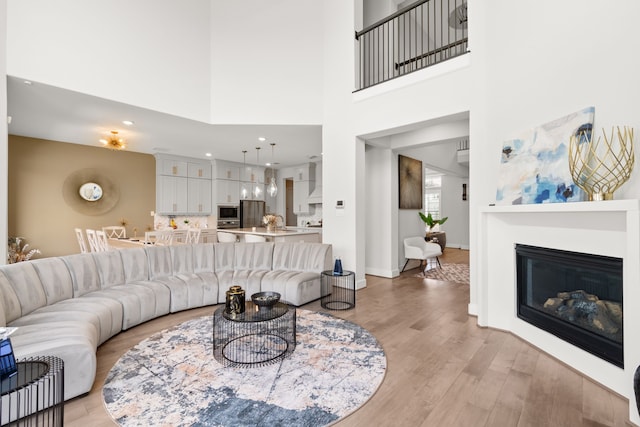 living room with a towering ceiling and light hardwood / wood-style floors