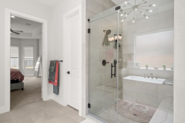 bathroom with shower with separate bathtub and ceiling fan with notable chandelier