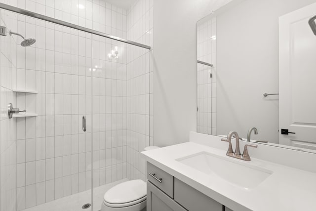 bathroom featuring vanity, toilet, and a shower with door