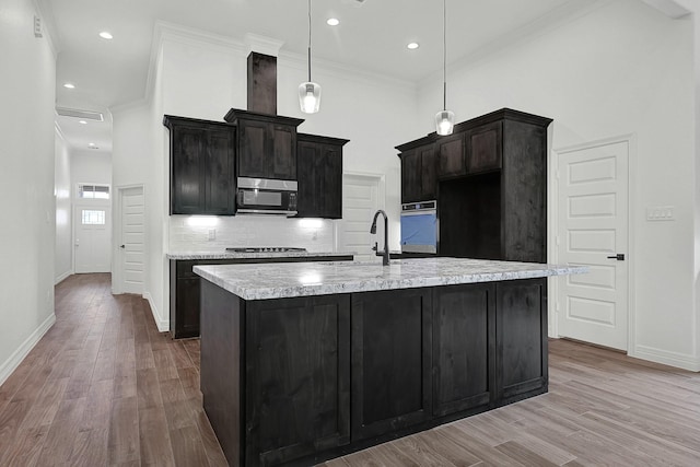525 Little Spring Ct, Anahuac, TX 77514 - kitchen featuring stainless steel appliances, wood finished floors, baseboards, light countertops, and an island with sink