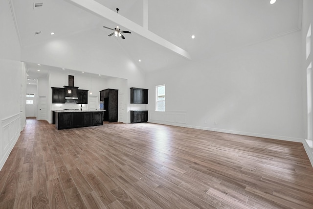 525 Little Spring Ct, Anahuac, TX 77514 - unfurnished living room with high vaulted ceiling, a ceiling fan, a fireplace, light wood-style flooring, and beamed ceiling