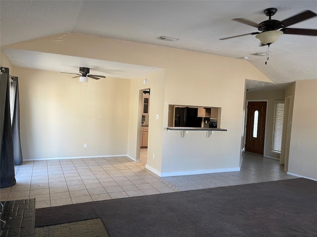 unfurnished living room with lofted ceiling, ceiling fan, and light tile patterned flooring