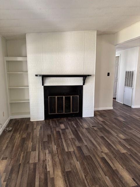 unfurnished living room featuring dark hardwood / wood-style floors and a brick fireplace