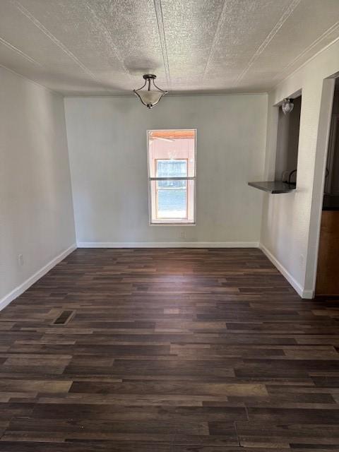 unfurnished dining area with dark hardwood / wood-style flooring and a textured ceiling