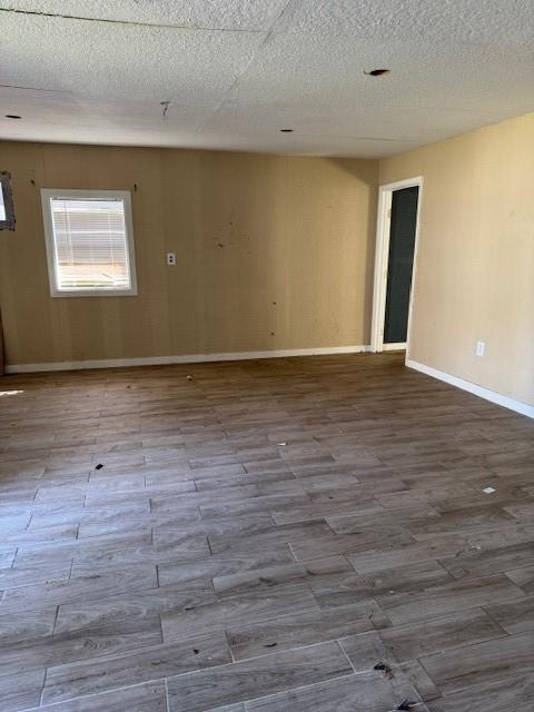 spare room featuring hardwood / wood-style floors and a textured ceiling