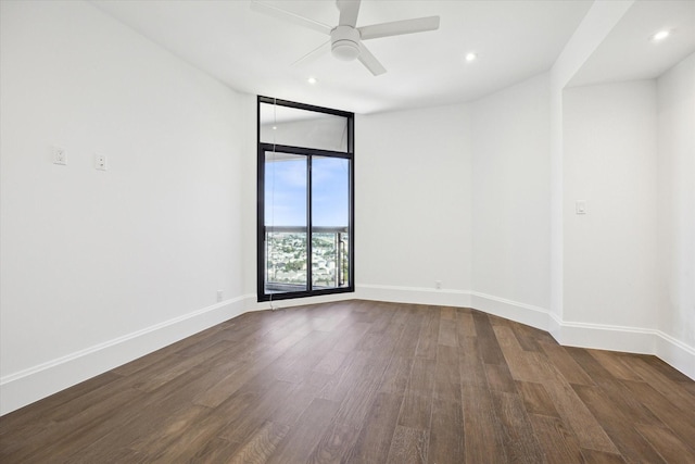 spare room featuring ceiling fan and dark wood-type flooring