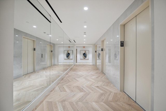 hallway with elevator and light parquet floors