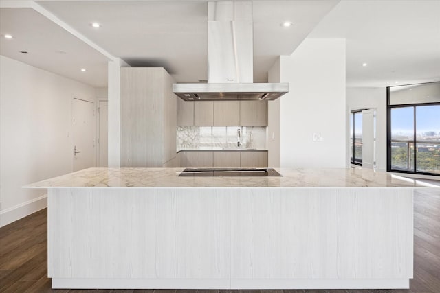 kitchen featuring island exhaust hood, light stone counters, light brown cabinets, and dark hardwood / wood-style floors