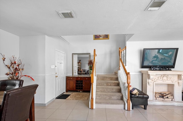 entrance foyer with light tile patterned flooring and a textured ceiling