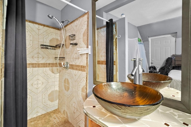 bathroom featuring a tile shower, tile patterned floors, and vanity